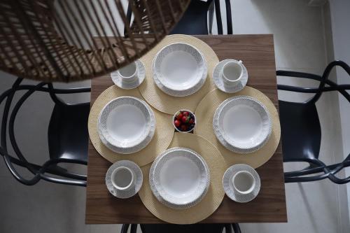 a table with white plates and a hat on it at BHB - ApartaHotel in Leticia