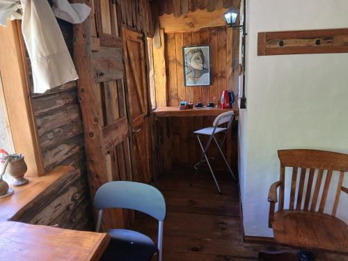 Zimmer mit Holzwänden, einem Tisch und einem Stuhl in der Unterkunft Posada Boutique- Casa de Campo Arroyo Huirihuiri in Aluminé