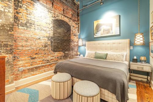 a bedroom with a bed and a brick wall at 80 Lex 203 Eclectic Industrial Apt in Asheville