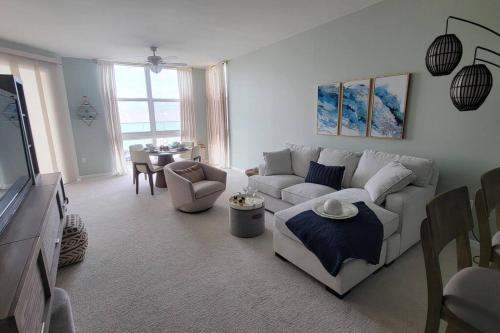 a living room with a white couch and a table at Turnkey Tranquility with Marina & Intercoastal views in Lantana