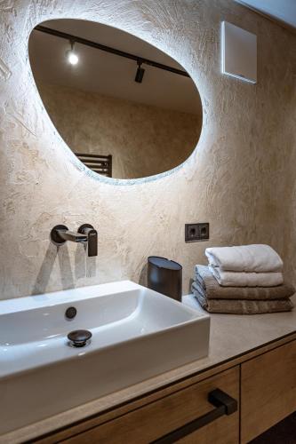 a bathroom with a sink and a large mirror at Jaggling Appartements in Sankt Ulrich am Pillersee
