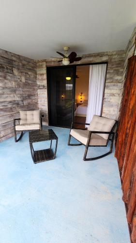 a room with two chairs and a bed and a bedroom at La Puesta del Sol B&B in Carrillo