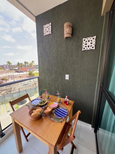 a wooden table with baskets of food on a balcony at Aláfia Porto de galinhas Mana beach in Porto De Galinhas