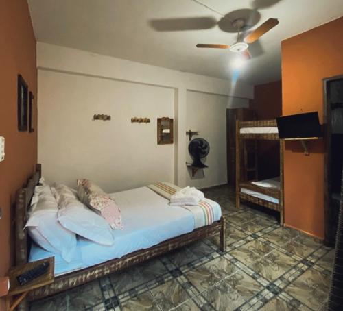 a bedroom with a bed and a ceiling fan at Trem de Pouso Rustic Guest House in Tiradentes