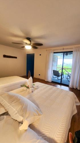 a bedroom with a large bed with a ceiling fan at La Puesta del Sol B&B in Carrillo