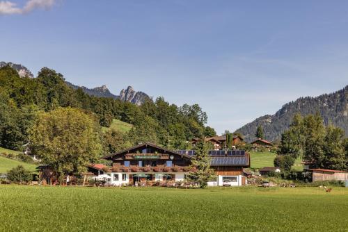 a large house in the middle of a green field at Wassererlehen in Bischofswiesen
