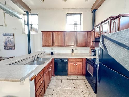 a kitchen with wooden cabinets and a sink at Sleepover 2BD 1BA Condos Downtown Springfield in Springfield