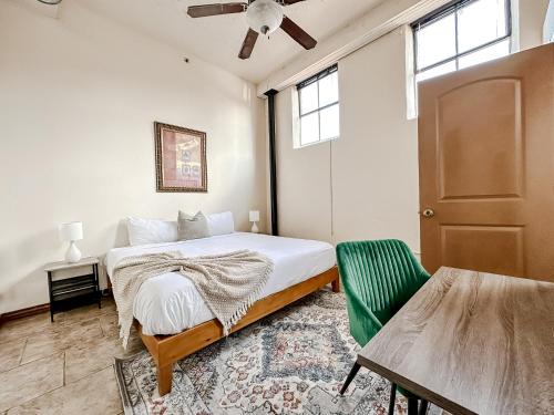 a bedroom with a bed and a green chair at Sleepover 2BD 1BA Condos Downtown Springfield in Springfield