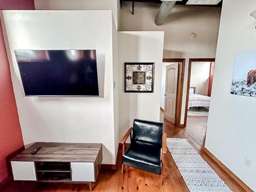 a living room with a black chair and a tv at Sleepover 2BD 1BA Condos Downtown Springfield in Springfield