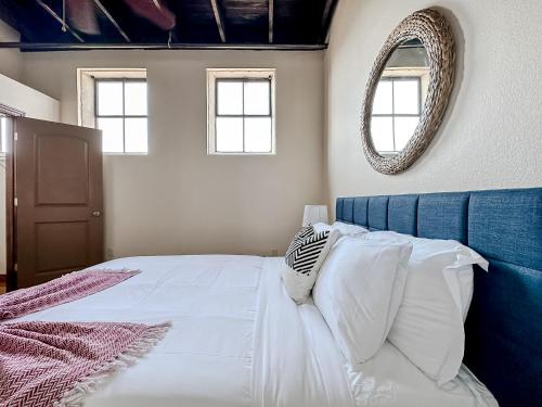 a bedroom with a bed with a blue headboard and a mirror at Sleepover 2BD 1BA Condos Downtown Springfield in Springfield