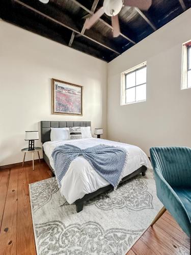 a bedroom with a large bed and a blue chair at Sleepover 2BD 1BA Condos Downtown Springfield in Springfield