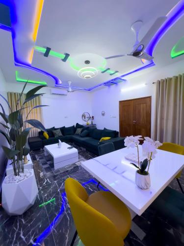a living room with a couch and a table and chairs at Adole Guest House in Abomey-Calavi