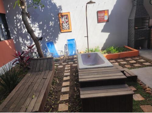 a bath tub sitting in a yard with two chairs at Trem de Pouso Rustic Guest House in Tiradentes