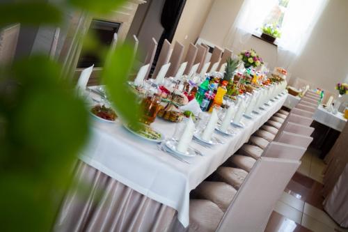 Vanilla House في Zwoleń: طاولة بيضاء طويلة عليها طعام ومشروبات