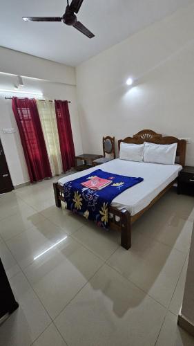 a bedroom with a bed with a blue blanket on it at Rak palace inn in Ayūr