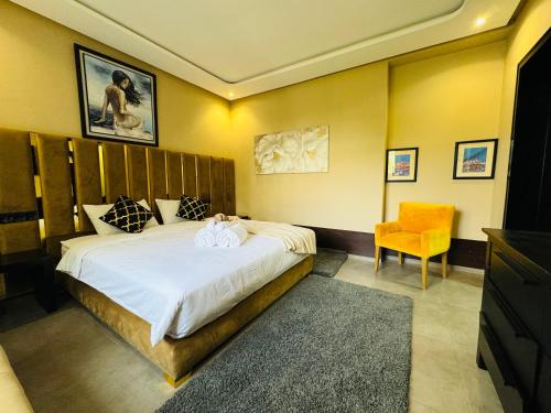 a bedroom with a large bed and a chair at Marina Panorama Apartement in Agadir