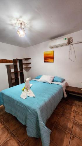 a bedroom with a blue bed with towels on it at La Puesta del Sol B&B in Carrillo