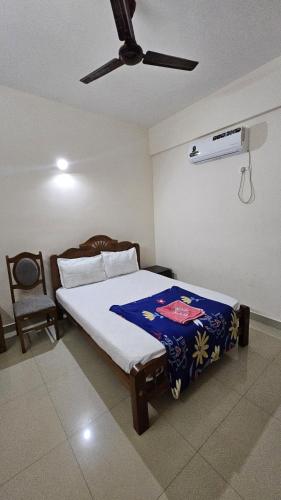 a bedroom with a bed and a ceiling fan at Rak palace inn in Ayūr
