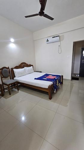 a bedroom with a bed and a ceiling fan at Rak palace inn in Ayūr