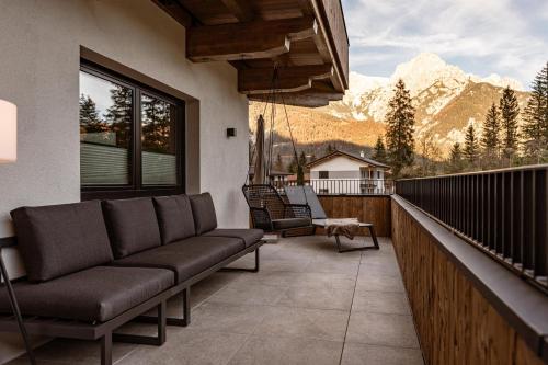 a couch on a balcony with a view of a mountain at Jaggling Appartements in Sankt Ulrich am Pillersee