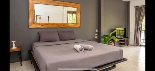 a bedroom with a bed with a mirror on the wall at Aqua Suites in Wok Tum