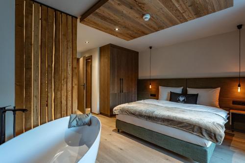a bedroom with a large bed and a bath tub at Jaggling Appartements in Sankt Ulrich am Pillersee