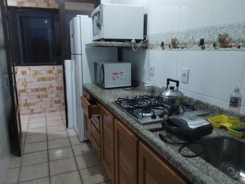 a kitchen with a stove with a tea kettle on it at Torres a mais bela praia gaúcha in Torres