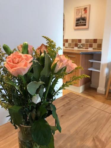 a vase filled with flowers on a wooden floor at Lovely centrally located 2 bed flat in Southsea in Portsmouth