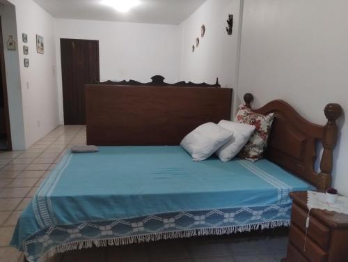 a bedroom with a bed with a wooden headboard at Torres a mais bela praia gaúcha in Torres