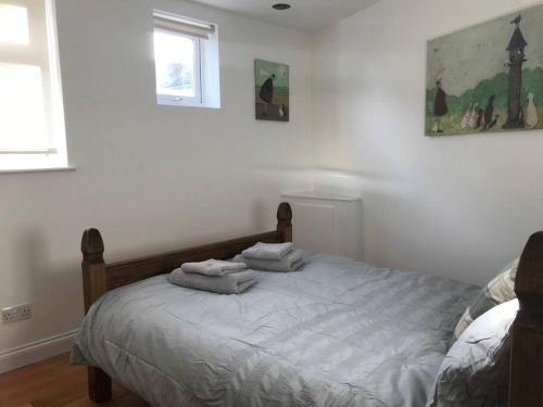 a bedroom with a bed with towels on it at Lovely centrally located 2 bed flat in Southsea in Portsmouth