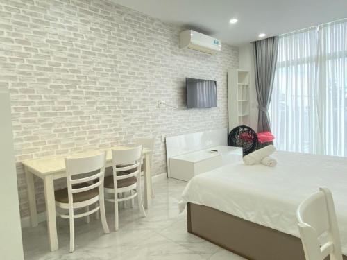 a bedroom with a bed and a table and chairs at Hotel,Căn Hộ Mũi Né Sea link in Phan Thiet