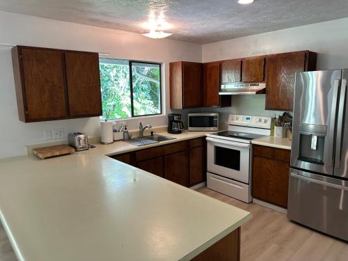 a kitchen with wooden cabinets and a white counter top at Best location, and recently renovated in Haleiwa