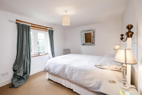 a white bedroom with a bed and a window at Stunning detached house near Bruton in Shepton Mallet
