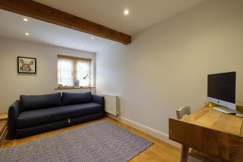 a living room with a couch and a flat screen tv at Stunning detached house near Bruton in Shepton Mallet