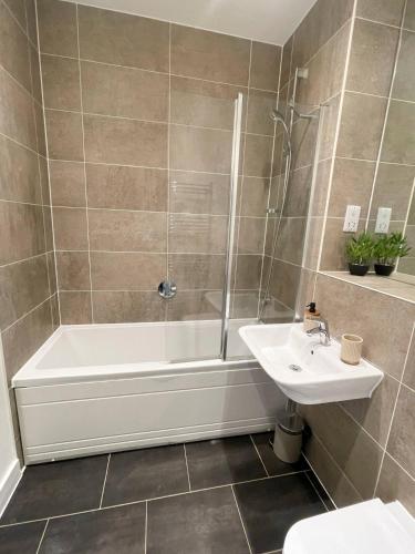 a bathroom with a shower tub and a sink at Central Luxury Peaceful Home With Driveway Parking - Cambridge Homehost in Cambridge