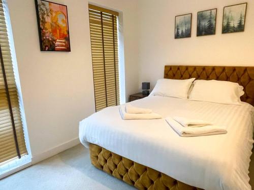 a bedroom with a large bed with two towels on it at Central Luxury Peaceful Home With Driveway Parking - Cambridge Homehost in Cambridge