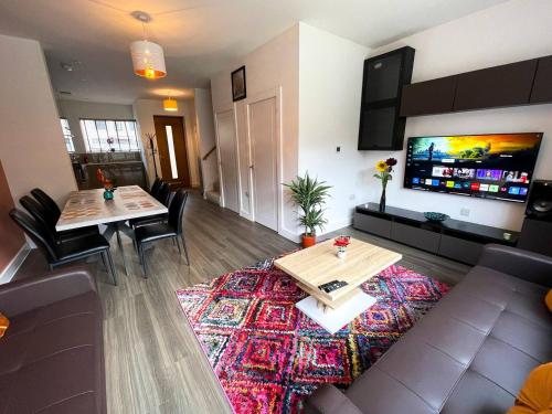 a living room with a couch and tables and a tv at Central Luxury Peaceful Home With Driveway Parking - Cambridge Homehost in Cambridge