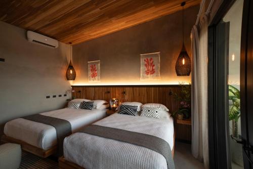 a bedroom with two beds in a room at Surf Synergy All-Inclusive Surf and Wellness Retreat in Jacó