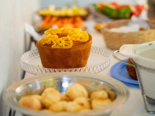 un tavolo con diversi piatti di cibo su di essi di Chácara Rosa Cortiana a São Gabriel