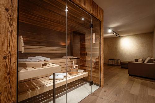 a bathroom with a glass walled shower with two beds at Jaggling Appartements in Sankt Ulrich am Pillersee
