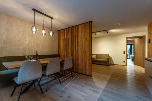 a dining room and living room with a table and chairs at Jaggling Appartements in Sankt Ulrich am Pillersee