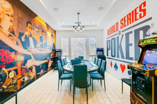a dining room with a table and arcade games at Hollywood Hideaway with 158" Poolside TV and 2 Arcades in Indio