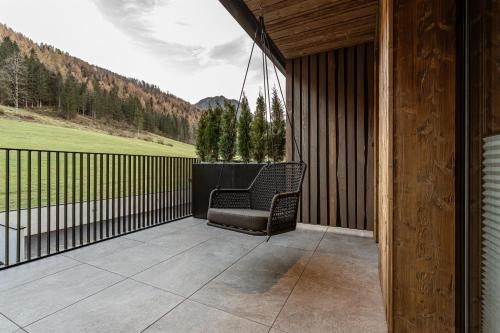 a chair on a porch with a view of a mountain at Jaggling Appartements in Sankt Ulrich am Pillersee