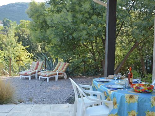 a blue table with chairs and wine bottles on it at Spacious holiday home by the river in Le Boulou