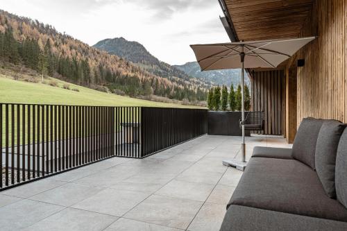 a patio with a couch and an umbrella at Jaggling Appartements in Sankt Ulrich am Pillersee