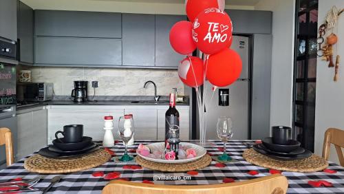 a table with red balloons and a bottle of wine at Villa Icaro in Sevilla