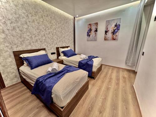 - une chambre avec 2 lits avec des draps bleus dans l'établissement Liliapart, à Agadir