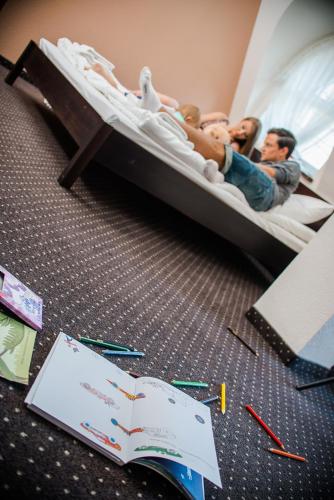 two men and a baby laying on a bed at Vanilla House in Zwoleń