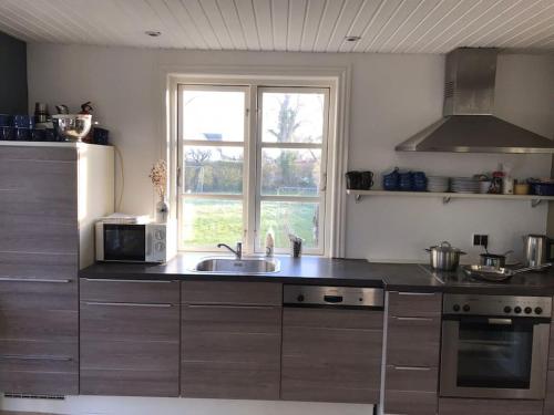 a kitchen with a sink and a window at Modern 2 bedroom cottage close to airport and town - sleeps 8 in Copenhagen