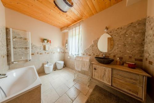 a bathroom with a tub and a sink and a mirror at Villa Le Cicale - Irpinia in Prata di Principato Ultra